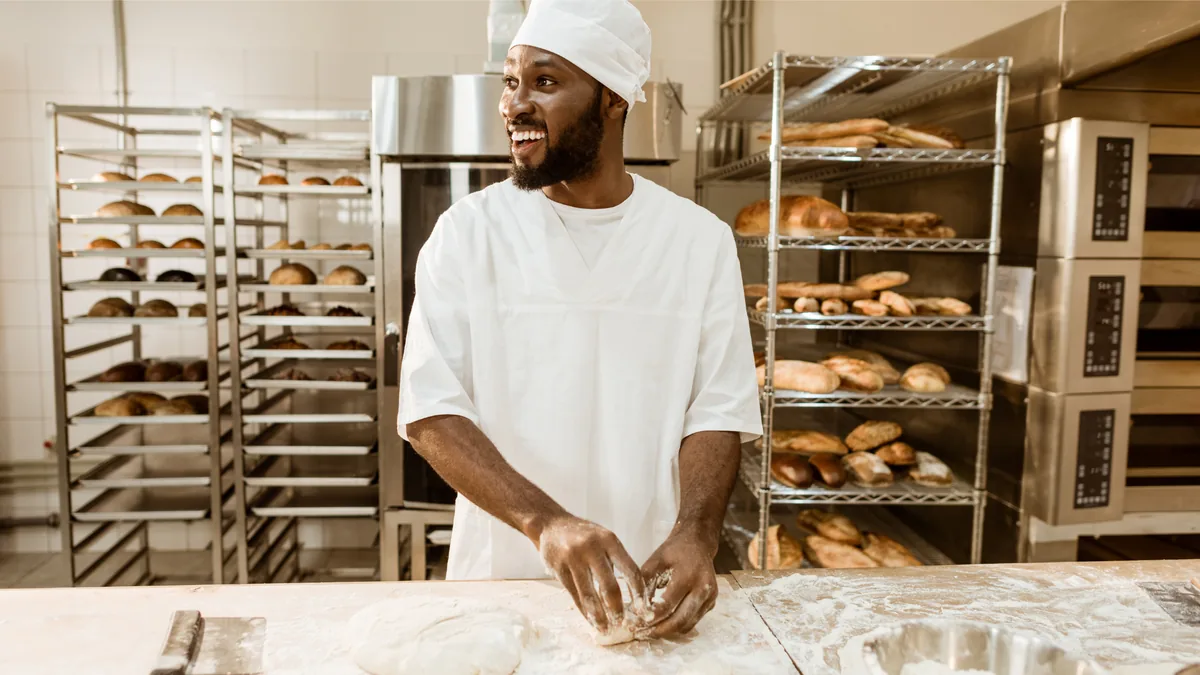 Boulanger artisan travaillant la pâte dans sa boulangerie