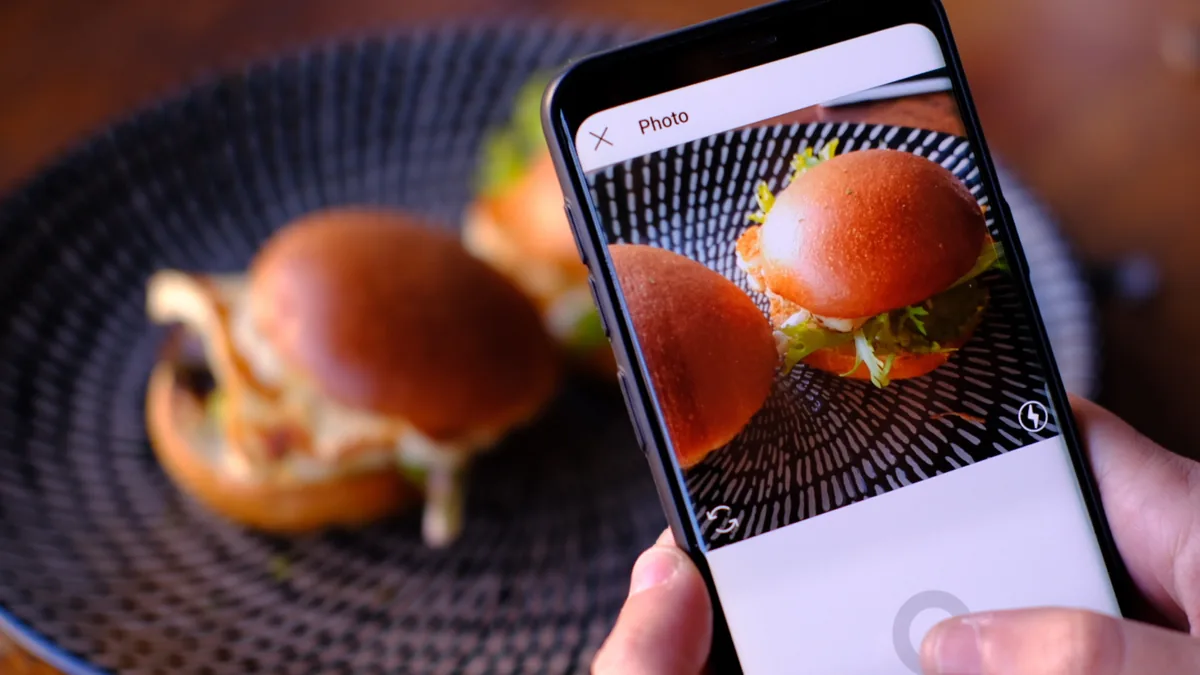 Smartphone filmant un burger pour les réseaux sociaux