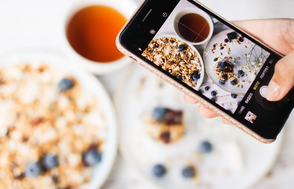 Smartphone photographiant un petit-déjeuner pour un contenu réseaux sociaux